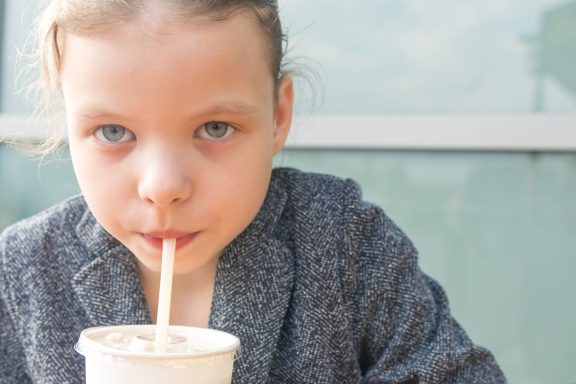 Young girl drinking through a straw